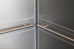 FSRT748 Интерьер лифта Levele-104 с панелями из нержавеющей стали с отделкой из песчаника; круглые поручни из сатинированной нержавеющей стали в магазине world of coca-cola, атланта, грузия Forms-surfaces